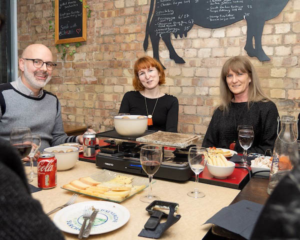 People having raclette in restaurant