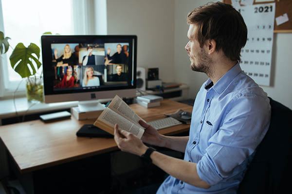 Man sitting at computer with book at book club