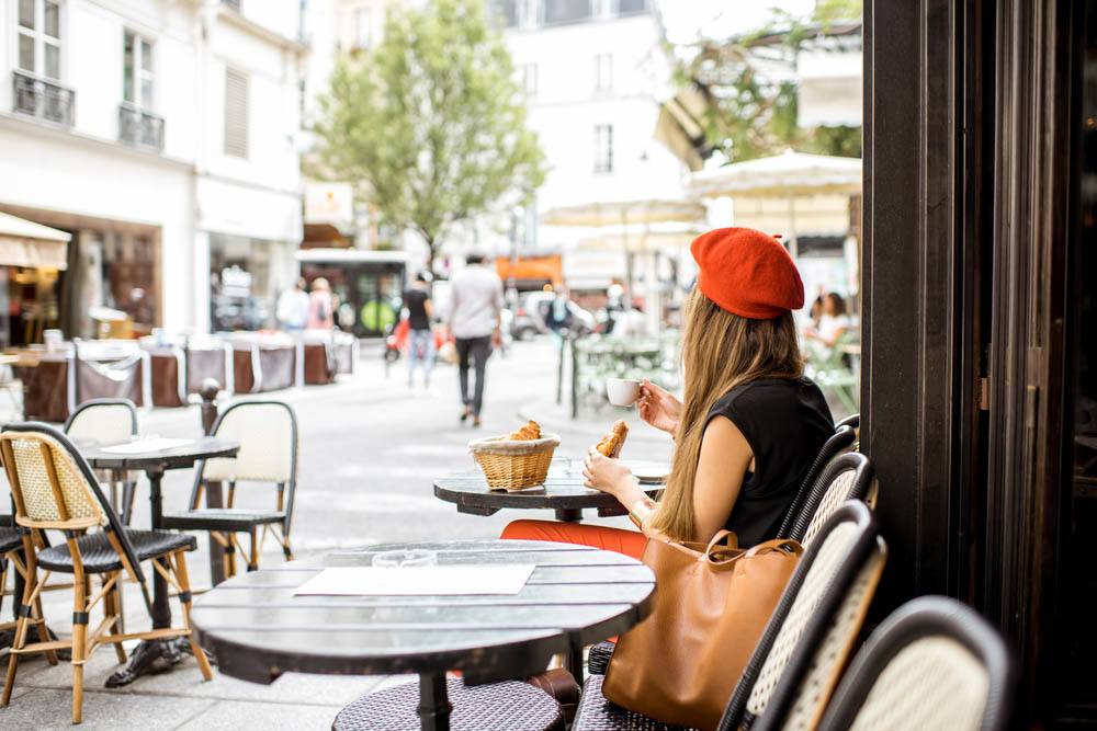Girl sitting outside cafe in Paris